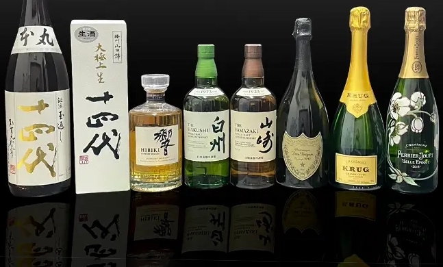 十四代、響、白州、山崎、ドン・ペリニヨン、クリュッグ、ペリエジュエなどの高級酒が横一列に並んだ画像。背景は黒で、ボトルの反射が床に映っている。